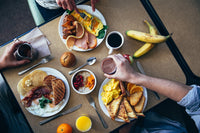 Table with food items such as pancakes, tea, coffee, banana etc